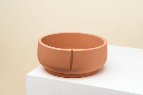 Een handgemaakte Pino Classic Feeder Foxy Terra bowl van duurzaam polysand, geschikt voor binnen en buiten. Met maatstrepen voor voedselhoeveelheid en unieke marmer-print.