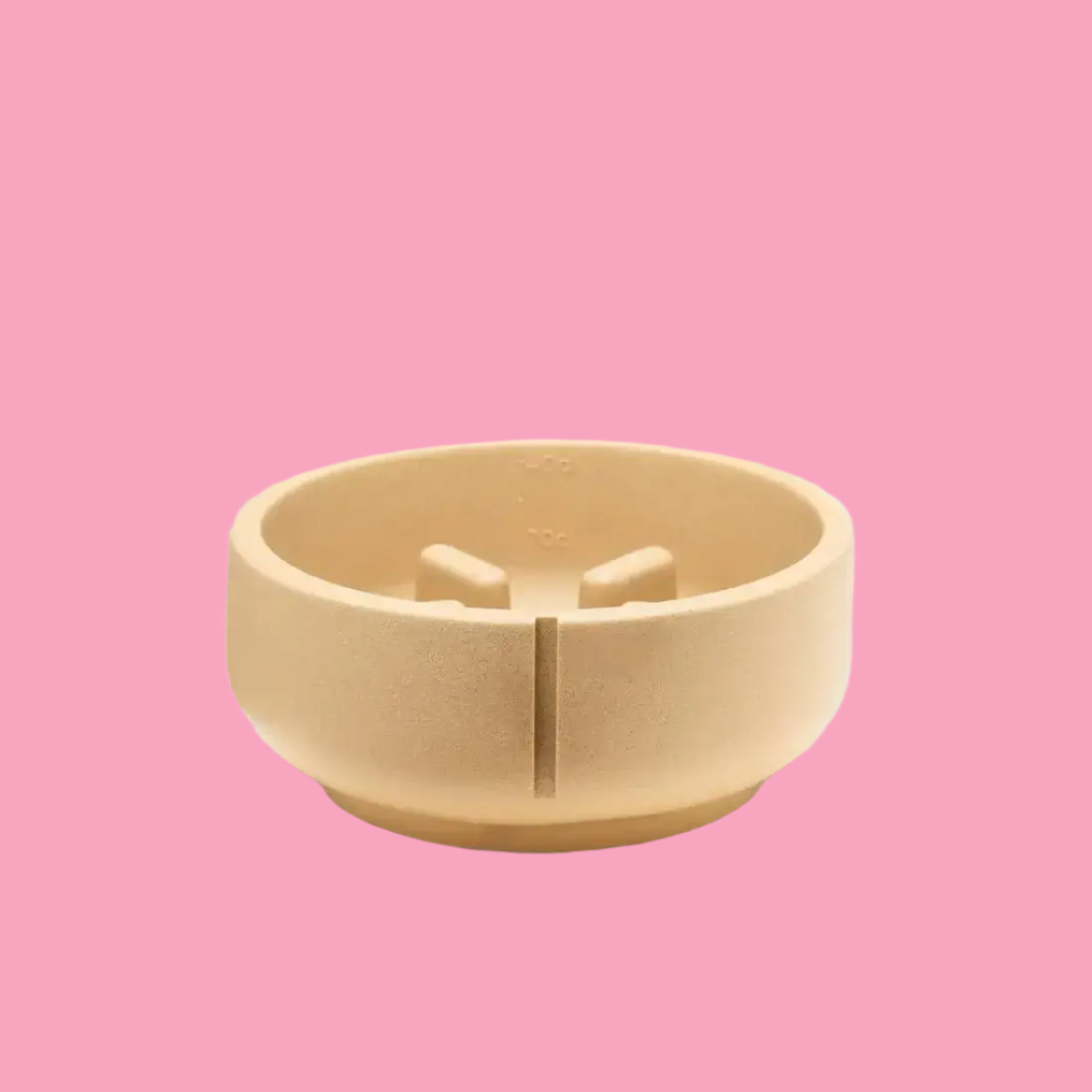 A beige, round, slow feeder dog bowl made of a heavy-duty material, placed on a white surface with a plain background.
